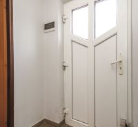 White entrance door in the interior with tiles in a family house.