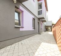 A family house on Kubranská Street in Trenčín with a paved courtyard and a brick wall.