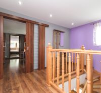 Staircase with railing and sliding doors, floor with wood decor, family house.