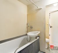 Bathroom in a 2-room apartment with a bathtub and a sink near the entrance door.