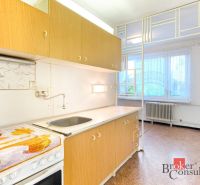 A kitchen with a unit in a 2-room apartment, a floor with a wooden decor, light walls.