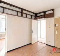 In the 2-room apartment, there is a bright room with built-in cabinets and a floor with a wooden decor.