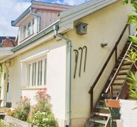 A family house in Rožňava with an outdoor staircase and a flower garden.