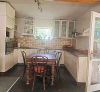 A family house kitchen with a dining table, fireplace, and wooden decor flooring.
