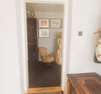 A family house with a hallway, an art sculpture, and coat racks in the interior.
