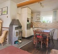 Interior of a family house with a kitchen, wooden sculpture, and fireplace, floor with wooden decor.