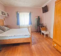A bedroom in a family house with classic furniture and a wooden decor floor.