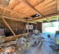 A wooden barn at the cottage in Dubové with tools and open doors.