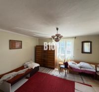 Room in a cottage with a bed, wardrobe, and retro decorations.