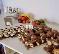 Snack bar in offices with refreshments, fruit, and water on a serving table.