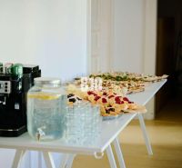 Office buffet with a coffee machine, a water pitcher, and snacks.
