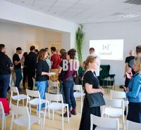 People discussing in an office with empty chairs and a presentation.