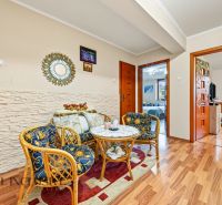 Living area with rattan furniture, wooden decor flooring, family house.