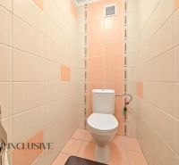 A bathroom with light tiles in a family house, simple design.