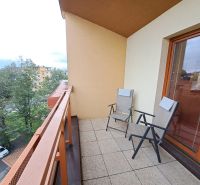 A balcony in a 2-room apartment on Štefánikova Street in Poprad with two chairs.