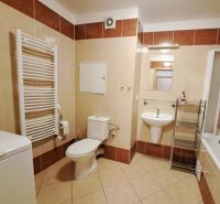 Bathroom in a 2-room apartment with a sink, bathtub, and washing machine.