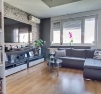 Living room in a 3-room apartment with a corner sofa and a floor with a wooden decor.