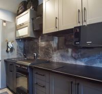 A kitchen in a 3-room apartment with gray cabinets and modern appliances.