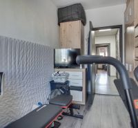 A room with a wooden decor floor and fitness equipment in a 3-room apartment.