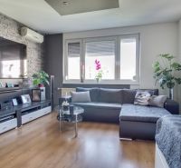 Living room in a 3-room apartment with a wooden decor floor and comfortable seating.