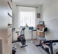 Home gym with an exercise bike and a bench, floor with wood decor.