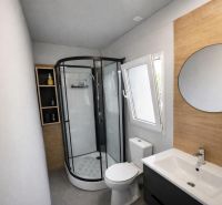 Bathroom in a holiday apartment with a modern shower and a mirrored wall.