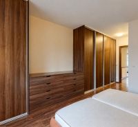 Bedroom with sliding wardrobes and wood-patterned flooring in a 3-room apartment.