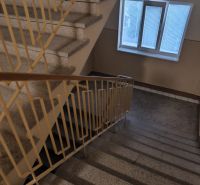 A hallway with a staircase in a 3-room apartment, with a window and a railing.