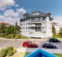 Street with an apartment building, parking, and greenery on Drotárska Road in Bratislava.