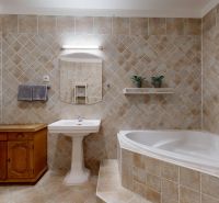 A bathroom in a 3-room apartment with a bathtub, a wooden cabinet, and tiles.