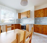 A kitchen with wooden cabinets and appliances in a 3-room apartment.
