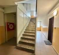 A corridor with interior stairs and doors leading to a 3-room apartment.