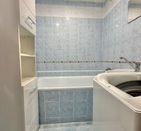 A bathroom with light blue tiles, a bathtub, and a white sink in a 3-room apartment.