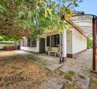 A family house in Lipové with a terrace, a column, and dining under the trees in the garden.