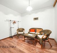 In the family house, there are rattan chairs, a table, and a floor with a wooden decor.