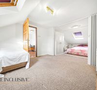 The attic of a family house with skylights, beds, and wardrobes.