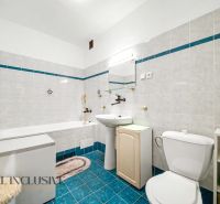 A bathroom in a family house with white tiles and a blue floor.