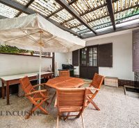 The terrace of a family house in Lipov with wooden garden furniture and a large umbrella.