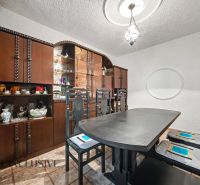 Dining room with a wooden sideboard and a dark table in a family house.