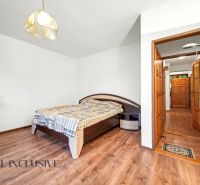 A bedroom in a family house with a bed and a wooden decor floor.