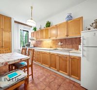 A kitchen in a family house with wooden cabinets and a dining table.
