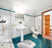 A bathroom with white tiles and turquoise flooring in a family house.