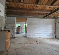 Interior with a view of the unfinished walls and wooden ceiling of a family house.