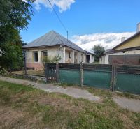 A family house in Kokšov-Bakša with a metal roof, fence, and porch.