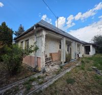A family house in Kokšov-Bakša with windows, a garden, and a blue sky in the background.