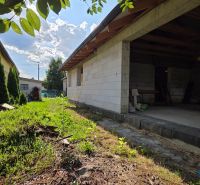 A family house in Kokšov-Bakša with a garden and an outdoor building on a summer day.
