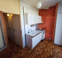 Compact kitchen in a studio apartment with a wooden decor floor and a simple kitchenette.