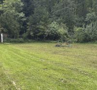 A lawn surrounded by forest near the cottages in Šugovská Valley, Medzev.