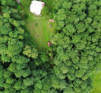 Aerial view of a cabin surrounded by dense forest in Šugovská Valley, Medzev.