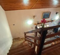 Stairs leading to the living room in a cabin with wooden decor on the ceiling.